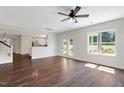 Bright living room with hardwood floors, a ceiling fan, and large windows that let in natural light at 315 Sugarpine Trl, Clayton, NC 27520