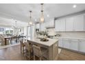 Bright kitchen featuring white cabinets, a central island with seating, and modern pendant lighting creating an inviting space at 361 Catheys Creek Cir, Wendell, NC 27591