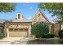 Charming stone house with a manicured lawn and mature trees, showing great curb appeal at 4137 Gardenlake Dr, Raleigh, NC 27612
