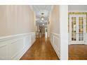 Elegant hallway with detailed molding, hardwood floors, and stylish lighting fixtures at 4137 Gardenlake Dr, Raleigh, NC 27612