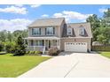 Beautiful two-story home with a welcoming front porch, complemented by lush green lawn at 44 Clarke Ct, Angier, NC 27592