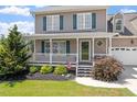 Inviting home showcasing a charming front porch and well-maintained landscaping at 44 Clarke Ct, Angier, NC 27592