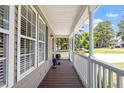 Covered front porch featuring a wood floor and a white decorative railing and columns at 44 Clarke Ct, Angier, NC 27592