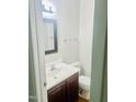 Cozy half-bath featuring a wood vanity and a framed mirror above the sink at 4418 Roller Ct, Raleigh, NC 27604