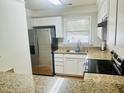Bright kitchen with stainless steel appliances, granite countertops, and white cabinets at 4418 Roller Ct, Raleigh, NC 27604