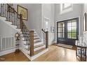 Grand foyer showcasing staircase, wood floors, and a front door with glass inserts at 623 Westfall Way, Chapel Hill, NC 27517
