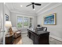 Home office with natural light, hardwood floors, tray ceiling and a large executive desk at 623 Westfall Way, Chapel Hill, NC 27517