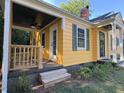 Exterior view of the home featuring a covered porch and freshly painted yellow siding at 719 E Whitaker Mill Rd, Raleigh, NC 27608
