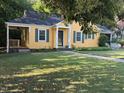 Charming yellow home with green shutters, covered parking, and a well-manicured lawn at 719 E Whitaker Mill Rd, Raleigh, NC 27608