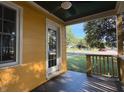 Covered porch with ceiling fan overlooking the front lawn, freshly painted yellow siding at 719 E Whitaker Mill Rd, Raleigh, NC 27608