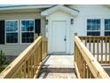 Inviting front door with wooden steps, porch, and sleek exterior lighting at 100 Cottonwood Ct, Kenly, NC 27542