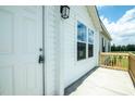 Close-up of the front door with a new wooden porch and exterior light fixture at 100 Cottonwood Ct, Kenly, NC 27542