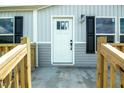 Inviting front entrance featuring a white door, black hardware, and a wooden porch railing at 101 Cottonwood Ct, Kenly, NC 27542