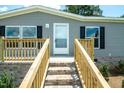 A nice gray home featuring a brick foundation and wooden porch at 103 Cottonwood Ct, Kenly, NC 27542