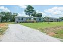 Bright and sunny home featuring a gravel driveway and well maintained lawn at 103 Cottonwood Ct, Kenly, NC 27542