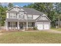 Inviting two-story home with a covered front porch and a well-manicured lawn at 115 Baystone Dr, Sanford, NC 27332