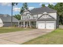 Attractive two-story home with a front porch and a two-car garage in a leafy neighborhood at 115 Baystone Dr, Sanford, NC 27332