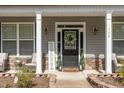 Welcoming front porch with seating, a wreath, and decorative plants at 115 Baystone Dr, Sanford, NC 27332