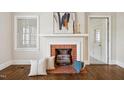 Close-up of a brick fireplace with wood logs, pillows, and decorative accents at 201 N Us 301, Micro, NC 27555