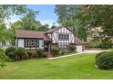 Charming Tudor-style home with manicured lawn, mature trees, brick accents, and a welcoming entrance at 2020 Port Royal Rd, Raleigh, NC 27609
