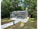 A charming home with a stone chimney and a well-manicured lawn surrounded by lush trees at 2022 Bivins St, Durham, NC 27707