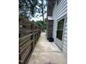 A narrow outdoor walkway with wooden fencing leads to the back entrance near a stone chimney at 2022 Bivins St, Durham, NC 27707