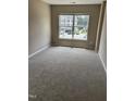 Cozy bedroom featuring neutral carpet and large window at 2221 Valley Edge Dr # 100, Raleigh, NC 27614