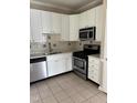 Updated kitchen with stainless steel appliances, white cabinets and tiled backsplash at 2221 Valley Edge Dr # 100, Raleigh, NC 27614