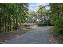A-frame brick home with a long driveway nestled among lush green trees and landscaping at 3863 Avents Ferry Rd, Sanford, NC 27330