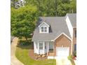 Charming two-story townhome with a brick and siding exterior, a well-manicured lawn, and an attached one-car garage at 428 Grand Pointe Dr, Garner, NC 27529