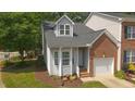 Charming two-story townhome with a brick and siding exterior, a well-manicured lawn, and an attached one-car garage at 428 Grand Pointe Dr, Garner, NC 27529