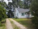 Charming cottage-style home with white siding, green shutters, and mature trees surrounding the property at 4503 Hopson Rd, Morrisville, NC 27560
