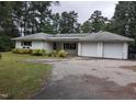 A bright, single-story ranch home features an attached two-car garage and a long asphalt driveway at 4511 Hopson Rd, Morrisville, NC 27560