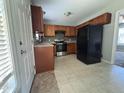 Functional kitchen with stainless steel appliances, brown cabinets, vinyl flooring, and modern fixtures at 6 Boxley Dr, Wendell, NC 27591
