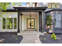 Grand entrance with stone steps, a modern black framed door, and stylish lighting fixture at 6701 Green Hollow Ct, Wake Forest, NC 27587