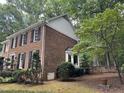 Brick two-story home with black shutters, a bay window, and a fenced yard at 7905 Breda Ct, Raleigh, NC 27606