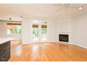 Bright living room boasts hardwood floors, a fireplace, French doors to the outside, and modern ceiling fan at 906 Stuart Dr, Mebane, NC 27302