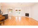 Bright living room boasts hardwood floors, a fireplace, French doors to the outside, and modern ceiling fan at 906 Stuart Dr, Mebane, NC 27302