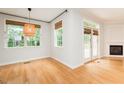 Bright living room boasts hardwood floors, a fireplace, French doors to the outside, and woven shade window coverings at 906 Stuart Dr, Mebane, NC 27302