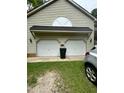 Spacious two-car garage with white doors, exterior lighting, and a well-kept lawn at 9160 Old Cascade Road Dr, Garner, NC 27529