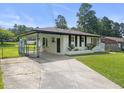 Well maintained exterior of a white home with a covered parking area and green lawn at 1020 Benning St, Durham, NC 27703