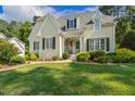 Inviting home with a well-manicured lawn and colorful landscaping, complemented by a classic light blue front door at 321 Wescott Ridge Dr, Holly Springs, NC 27540