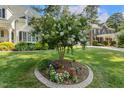 Lush green lawn showcases a lovely crape myrtle tree surrounded by colorful flower beds at 321 Wescott Ridge Dr, Holly Springs, NC 27540