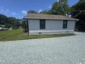 Side view of a white house with a gravel driveway, showcasing its clean lines at 3241 Rowena, Durham, NC 27703