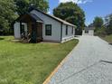 Exterior of a cozy home showing a gravel driveway and side entrance at 3241 Rowena, Durham, NC 27703
