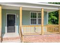 Inviting front porch with brick base, wooden railings, posts, and a view of the entry door at 1408 South St, Durham, NC 27707
