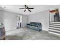 Cozy living room featuring tile flooring, a ceiling fan, and a comfortable black leather sofa at 5209 Amsterdam Pl, Raleigh, NC 27606
