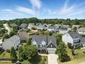 Aerial view of a beautifully landscaped home nestled within a vibrant, tree-lined neighborhood on a sunny day at 5716 Sarcelle St, Holly Springs, NC 27540