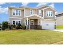 Two-story home featuring a blue front door and an attached two-car garage with verdant lawn at 812 Teal Lake Dr, Holly Springs, NC 27540