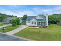 A well-maintained, one story home features a long driveway and an attached garage at 104 Roscommon Ln, Clayton, NC 27520